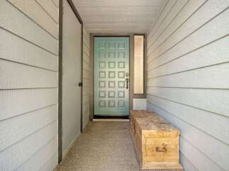 Step into this charming entryway featuring a light blue paneled door, perfect for welcoming guests.