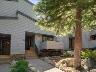 Discover this charming property featuring a welcoming entryway with a stone accent base and a paved walkway leading to the front doors.