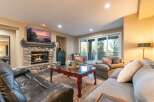 Experience luxurious living in this stunning great room, featuring a magnificent stone fireplace and a large flat-screen TV perfect for cozy evenings.