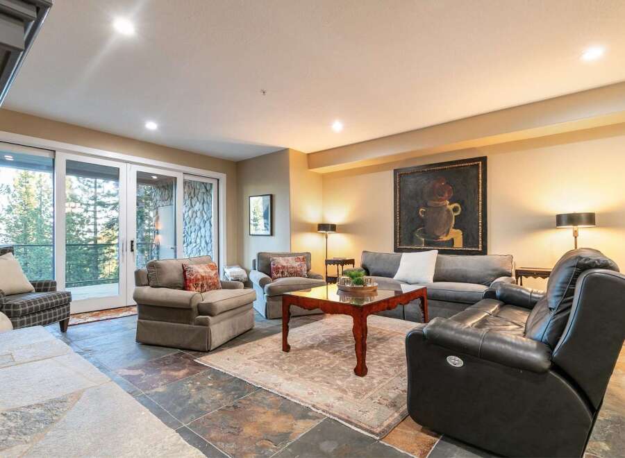 Experience luxurious living in this inviting living room, featuring a plush sectional sofa and comfortable armchairs perfect for relaxation.