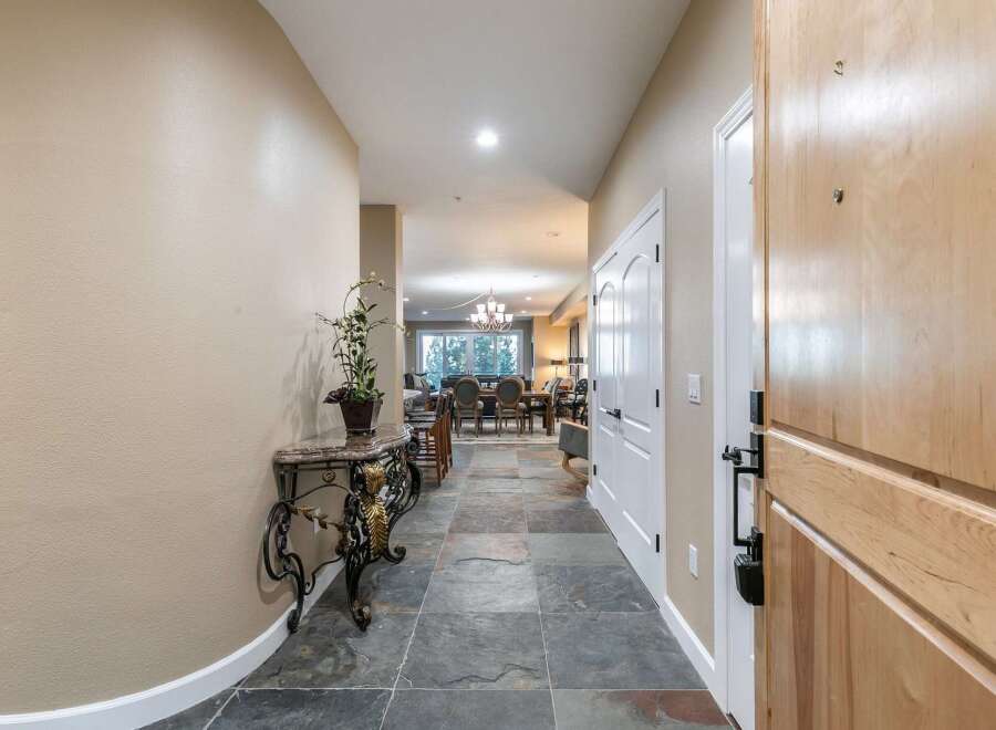 Step into this inviting entryway featuring elegant slate tile flooring and a decorative console table with a potted plant.