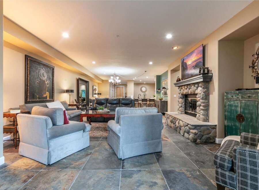 This spacious living area features a large stone fireplace as the focal point, perfect for cozy evenings.