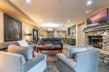 Experience luxury living in this spacious great room, featuring a cozy stone fireplace and a large flat-screen TV perfect for entertaining.