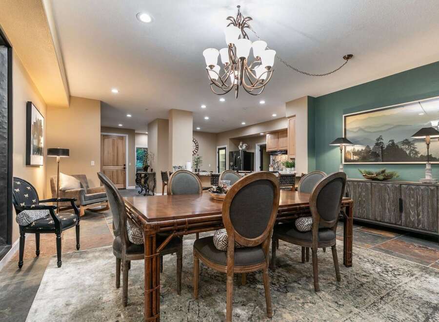 This spacious dining room features a large wooden table with upholstered chairs, perfect for family gatherings.