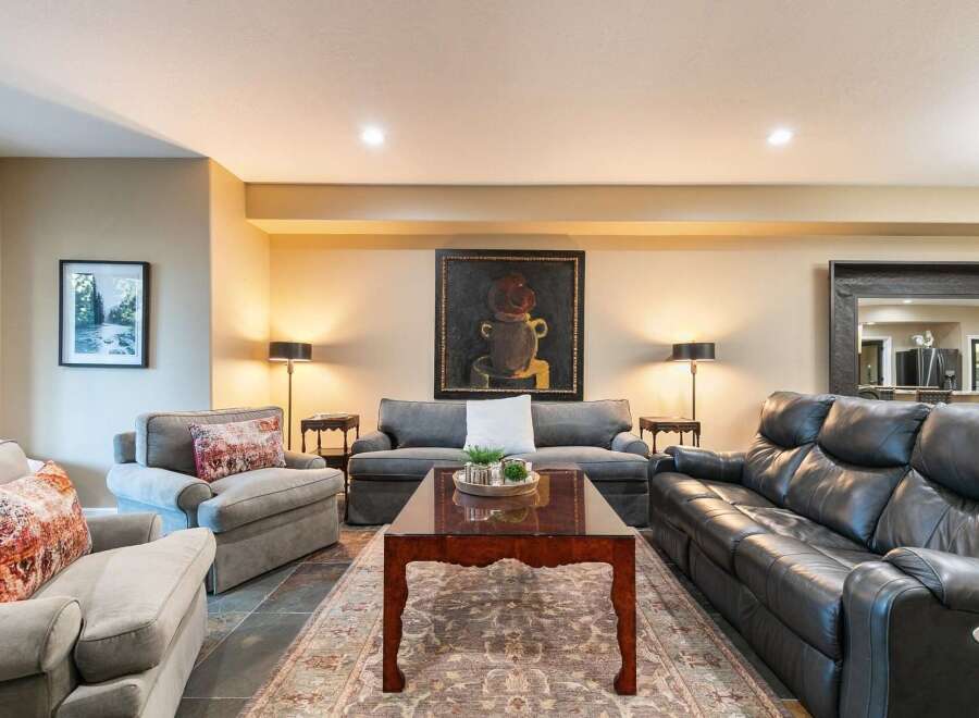 This inviting living room features a plush gray sofa and two comfortable armchairs, perfect for relaxation.