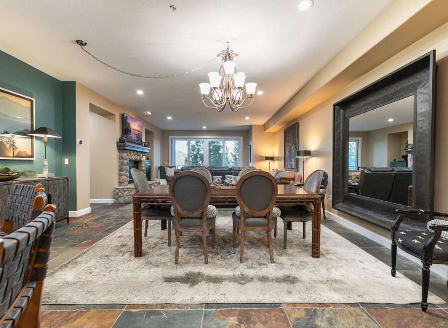 This spacious dining and living area features a large wooden dining table with upholstered chairs, perfect for family gatherings.