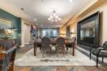 This spacious dining and living area features a large wooden dining table with upholstered chairs, perfect for family gatherings.