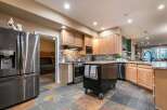 This spacious kitchen features a large stainless steel refrigerator and ample wooden cabinetry, perfect for storage.