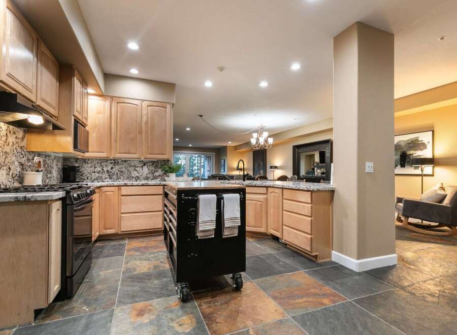 Experience the perfect blend of style and functionality in this stunning kitchen, featuring elegant wood cabinetry and a sleek granite countertop.