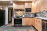 This kitchen features light wood cabinetry and a striking granite backsplash that adds a touch of elegance.