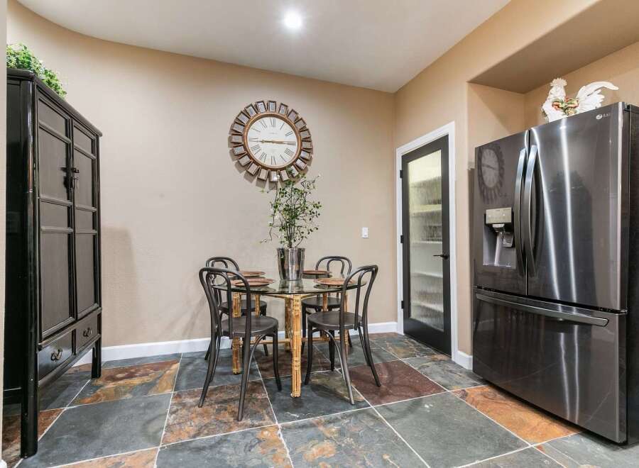 This dining area features a stylish glass-top table with four chairs, perfect for intimate meals.