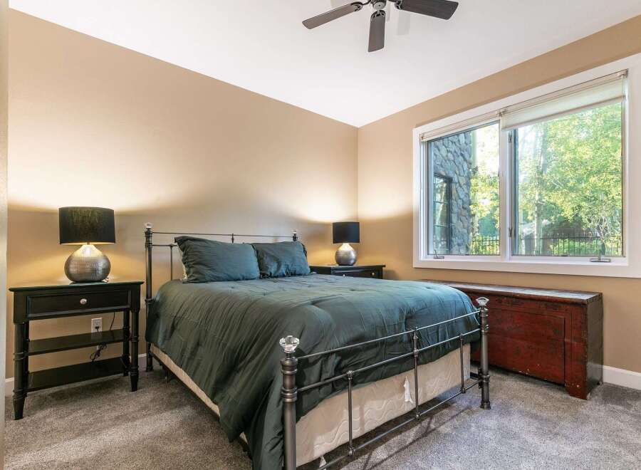 Experience comfort and style in this inviting bedroom, featuring a plush queen-size bed adorned with deep green linens.