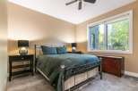 Experience comfort and style in this inviting bedroom, featuring a plush queen-size bed adorned with deep green linens.