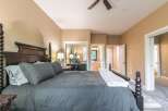 Experience luxury and comfort in this master suite, featuring a grand four-poster bed adorned with plush grey linens and accent pillows.