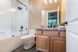 This modern bathroom features a sleek glass-enclosed shower and tub combination, complemented by a clean white tiled backsplash.