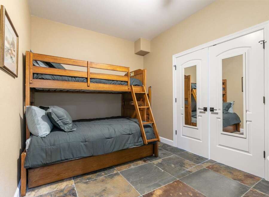 This charming bedroom features a sturdy wooden bunk bed, perfect for accommodating guests or family.
