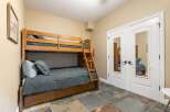 This charming bedroom features a sturdy wooden bunk bed, perfect for accommodating guests or family.
