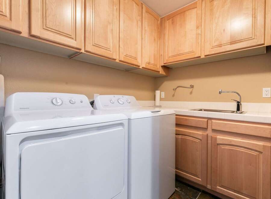 This laundry room features a convenient setup with a white Hotpoint washer and dryer.