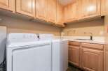This laundry room features a convenient setup with a white Hotpoint washer and dryer.