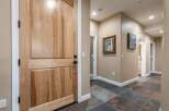 Step into this inviting entryway featuring a beautiful natural wood door and elegant slate tile flooring.