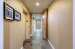 Step into this inviting hallway featuring a convenient elevator and a charming wooden door leading to an outdoor space.