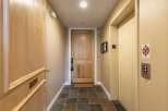 Discover this charming hallway featuring a sturdy wooden door and a convenient elevator.