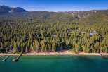 Experience the ultimate lakeside lifestyle with this stunning aerial view of a pristine beach and crystal-clear turquoise waters.