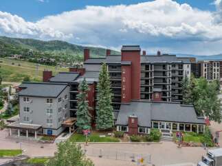 Experience luxury mountain living in this stunning condominium complex, offering breathtaking views of the surrounding ski slopes and verdant hills.