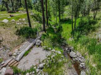 Discover a serene outdoor oasis with a charming stone patio, perfect for enjoying the natural beauty of this wooded property.