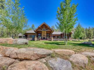 Experience rustic luxury in this stunning log cabin home, nestled amidst a serene forest landscape.