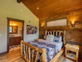 Experience rustic charm in this cozy bedroom featuring a unique log bed adorned with a Southwestern-inspired quilt.