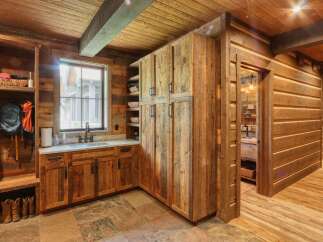 Experience rustic charm in this mountain-inspired home, featuring a functional mudroom with ample storage and a convenient sink area.