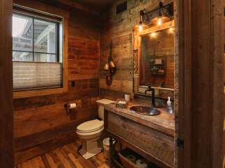 Experience rustic charm in this bathroom featuring reclaimed wood paneling throughout, creating a warm and inviting atmosphere.