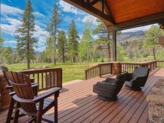 Enjoy breathtaking mountain views from this expansive covered deck, perfect for outdoor living and entertaining.