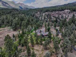 Nestled amidst a dense pine forest and rugged mountain terrain, this stunning property offers unparalleled privacy and natural beauty.