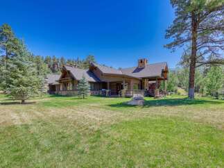 Experience luxurious mountain living in this stunning log home, nestled amidst towering pines and offering breathtaking natural beauty.