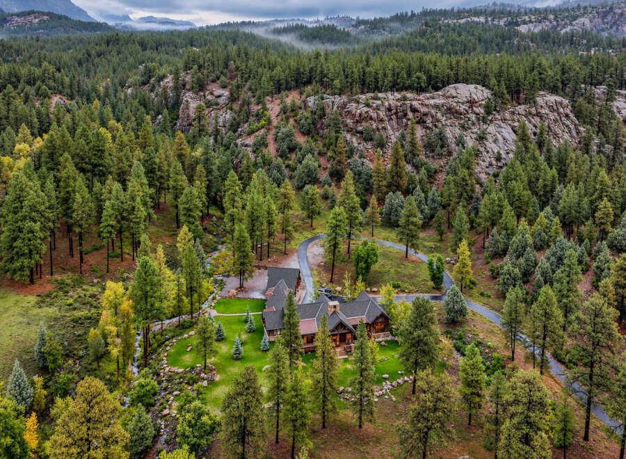 Nestled amidst a dense pine forest and rugged rock formations, this stunning property offers a secluded mountain retreat.
