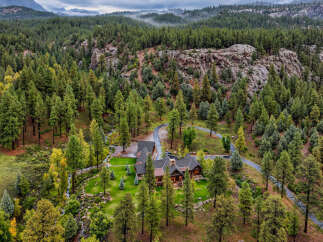 Nestled amidst a dense pine forest and rugged rock formations, this stunning property offers a secluded mountain retreat.