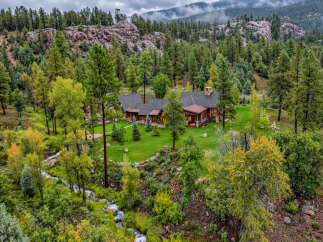 Nestled amidst a lush forest and a babbling creek, this stunning mountain home offers unparalleled tranquility and natural beauty.