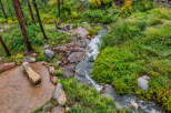 Discover a serene retreat with this charming outdoor seating area, perfectly situated beside a babbling brook.