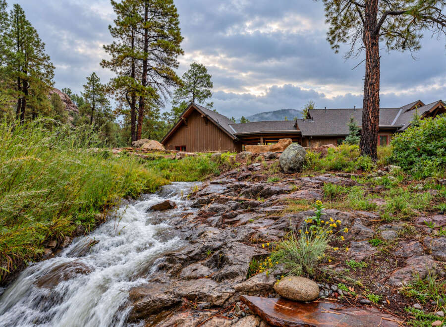 Nestled amidst a serene natural landscape, this property features a charming wooden home with a rustic aesthetic.