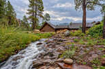 Nestled amidst a serene natural landscape, this property features a charming wooden home with a rustic aesthetic.