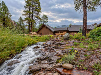 Nestled amidst a serene natural landscape, this property features a charming wooden home with a rustic aesthetic.