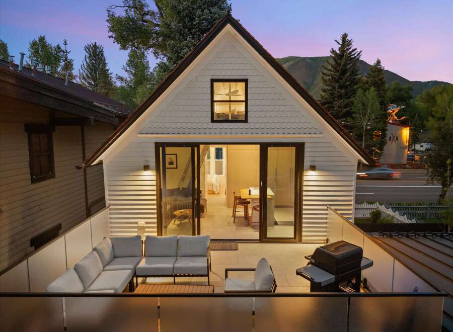 Enjoy stunning mountain views from this modern home featuring a spacious outdoor patio with comfortable seating and a grill.