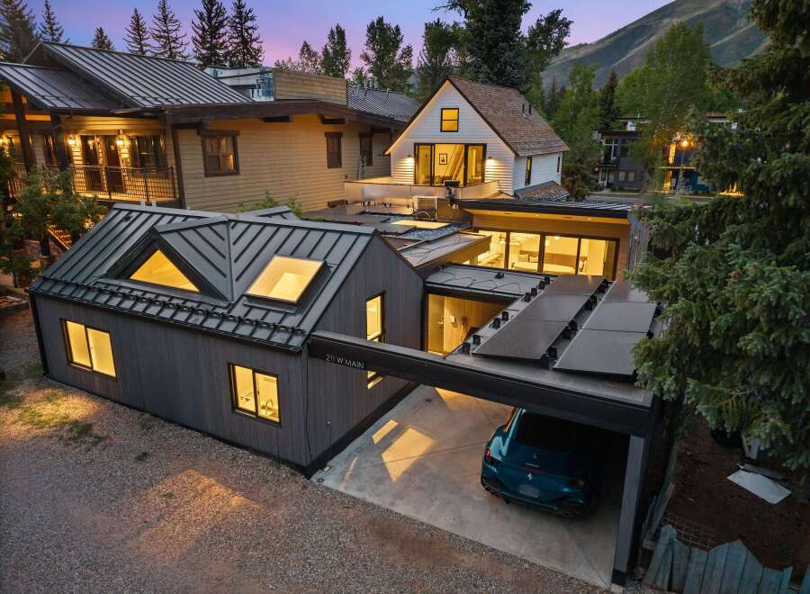 Experience modern luxury in this stunning property featuring a sleek metal roof and integrated solar panels for sustainable living.