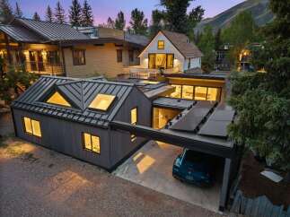 Experience modern luxury in this stunning property featuring a sleek metal roof and integrated solar panels for sustainable living.