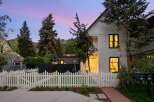 Charming home with a white picket fence and a welcoming brick pathway leading to the entrance.