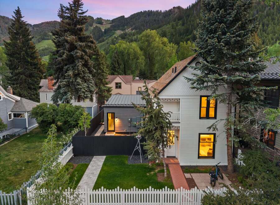 Nestled against a backdrop of majestic mountains, this charming home offers a serene retreat with its inviting facade and lush landscaping.