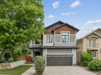 Discover this stunning modern home featuring a striking facade with a mix of stone, stucco, and wood accents.
