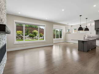 Experience modern living in this open-concept home featuring a stunning stone fireplace and expansive windows that flood the space with natural light.